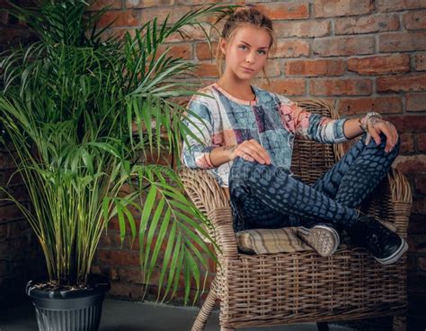Blonde Girl Sits On A Chair In A Room With Green Palm Stock Image Image Of Pretty Positive