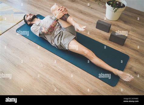 Man On Yoga Mat In Pawanmuktasana Wind Relieving Pose Early In The