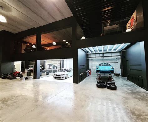 An Empty Garage With Two Cars Parked In The Space Between It And