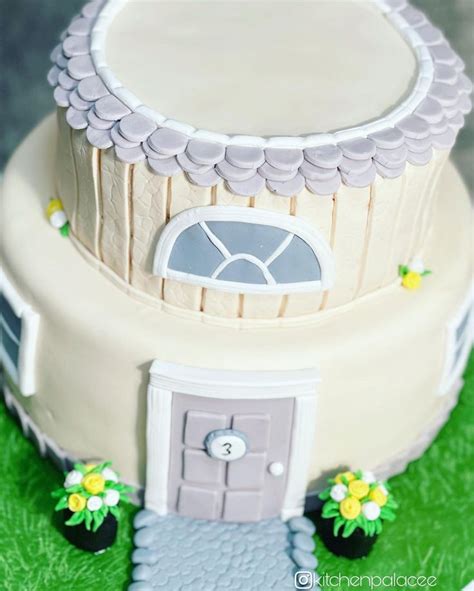 This Is A Cake With A House On It S Side And Flowers Around The Door