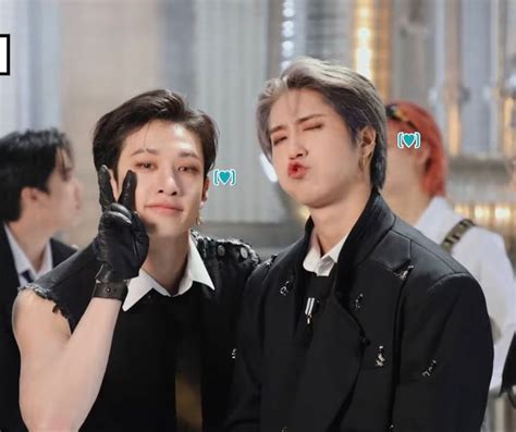 two young men standing next to each other with their hands in the shape ...