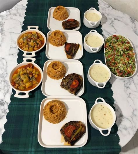 A Table Topped With Plates And Bowls Filled With Food Next To Dips On Trays