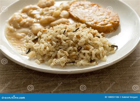 Chuleta De Cerdo Arroz Moreno Y Habas Blancas Plato Blanco En Tabl De