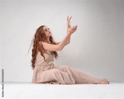 Full Length Portrait Of Beautiful Brunette Model Wearing A Pink Dress Graceful Sitting Pose