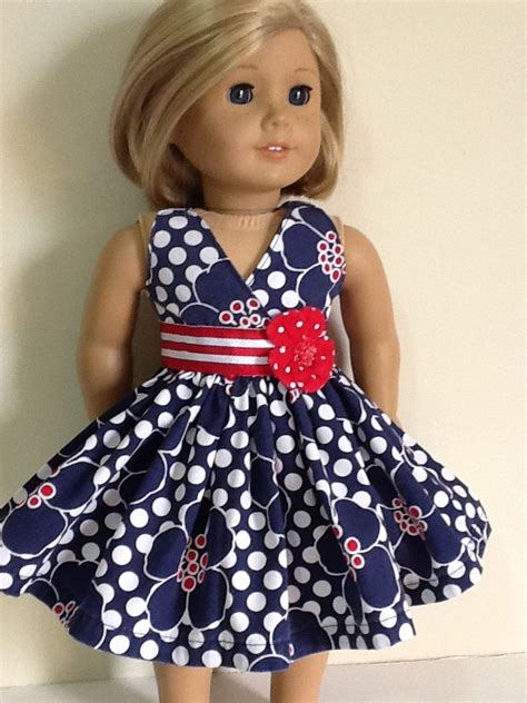 A Doll With Blonde Hair Wearing A Blue And White Polka Dot Dress Red Bow