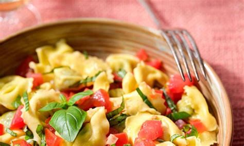 A Wooden Bowl Filled With Pasta And Veggies