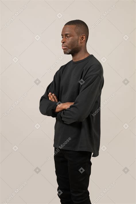 Side View Of A Calm Young Guy Standing With Arms Crossed Photo