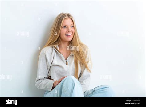 Portrait Of A Year Old Blonde Woman Leaning Against A White