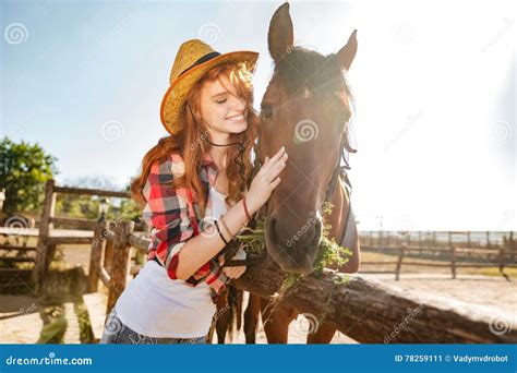 Vaqueira De Sorriso Da Mulher Que Ciao E O Aperto De Seu Cavalo Imagem