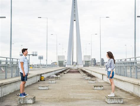 Couple Standing Toward Each Other And Smiling In The Urban Area By