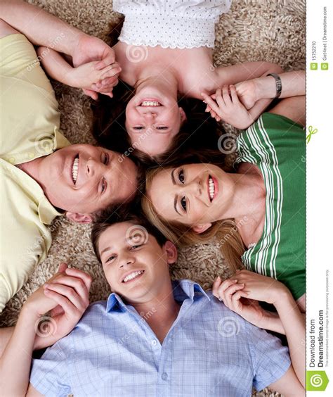 Familia De Cuatro Miembros Feliz Que Miente En La Alfombra Foto De