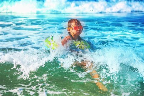 Un Niño Feliz Se Divierte En El Surf En La Playa Niño Alegre En El