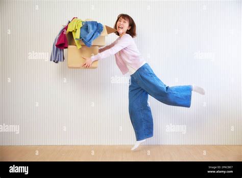 Woman Carrying Clothes In Cardboard Boxes Stock Photo Alamy