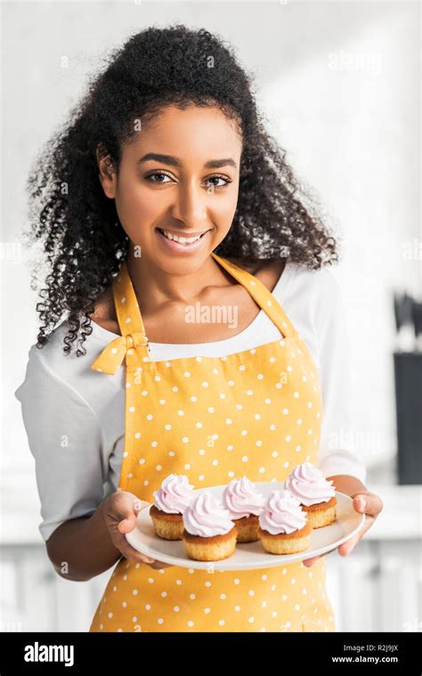 Portrait Of Smiling Attractive African American Girl In Apron Holding