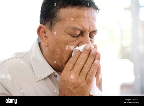 Man Sneezing Into A Handkerchief Stock Photo Alamy