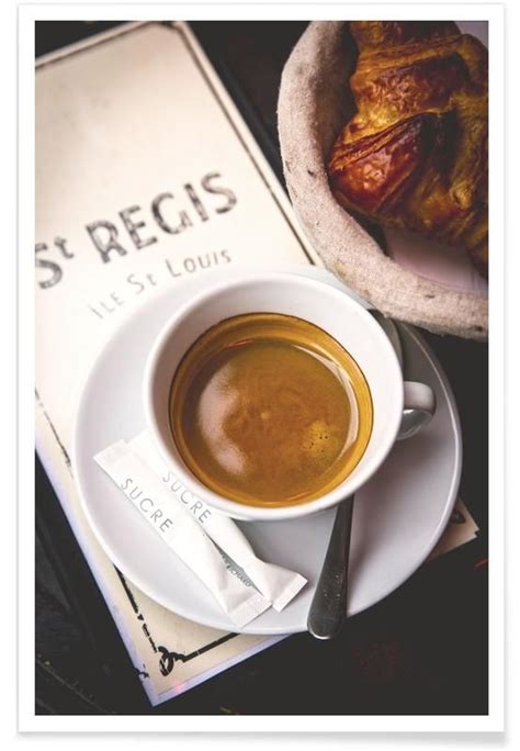 A Cup Of Coffee Sitting On Top Of A White Saucer Next To A Book