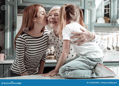 Loving Daughter And Granddaughter Kissing Granny And Showing Their Love