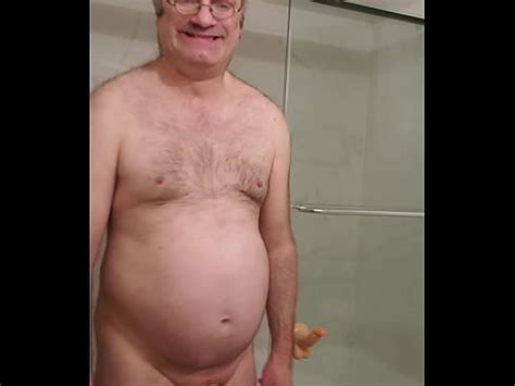 Nude Martin Lavallée sodomizes himself and juxtaposes his caged penis with his 8 inch dildo