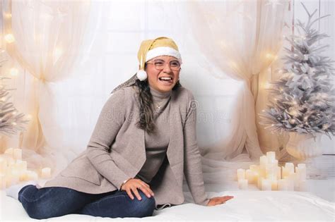 30 Year Old Latina Woman With Glasses And Santa Hat Next To The Decorated Tree Is Excited To