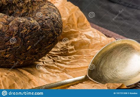 Chinese Pressed PU Erh Tea On Wrapping Paper And Tea Accessories On A