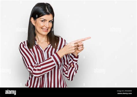 Beautiful Brunette Woman Wearing Striped Shirt Smiling And Looking At