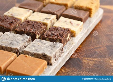 An Assortment Of Various Flavors Of Fudge On A Wood Butcher Block Stock