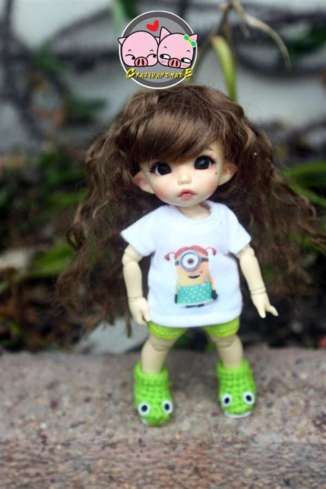 A Doll With Long Brown Hair Wearing Green Shoes And A T Shirt That