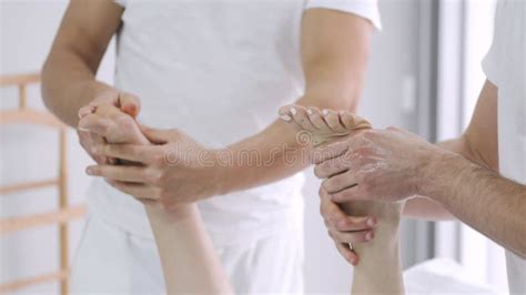 Two Male Masseurs Working With Woman Japanese Feet Massage With Bamboo