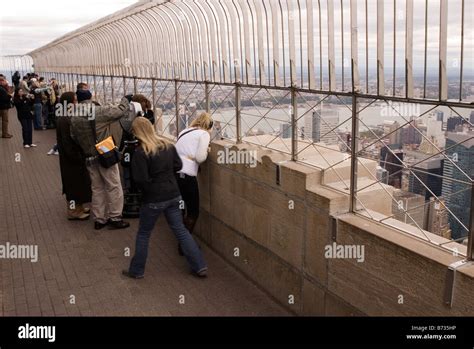 Tourists on the outside viewing deck of the Empire State Building ...