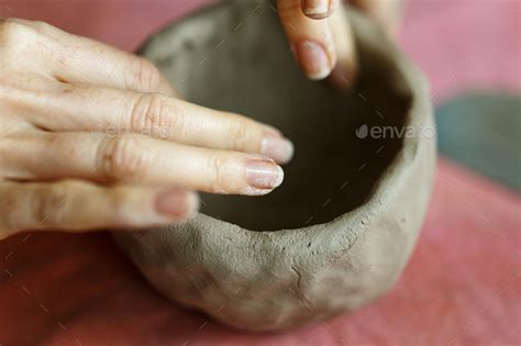 Womens Hands Knead The Clay And Sculpt A Cup Or Bowl From It The