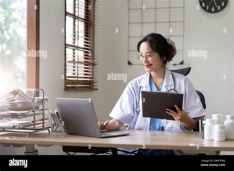 Asian Doctor Working With Laptop In Hospital And Medical Stethoscope