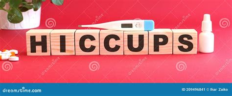 The Word Hiccups Is Made Of Wooden Cubes On A Red Background Medical