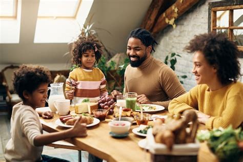 Familia Negra Feliz Disfrutando De La Comida En La Mesa De Comedor En