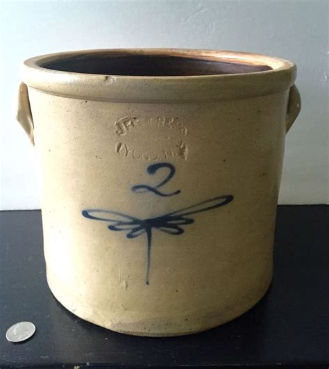 A Ceramic Pot With A Dragonfly Design On It