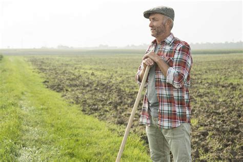 Farmer Standing In Front Of A Field Stock Photo