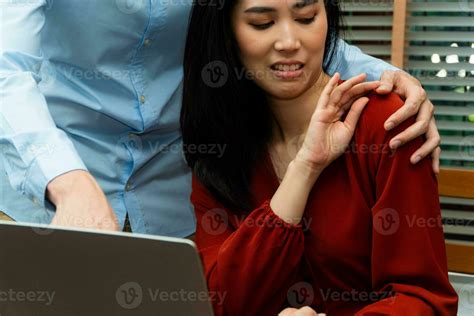 Boss Touching Shoulder Of A Young Female Employee In Office At Workplace She Is Uncomfortable