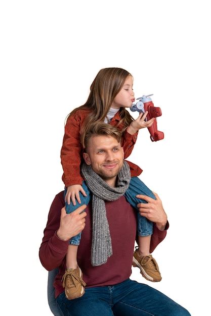 Retrato de padre e hija jugando con un avión de juguete antes de viajar