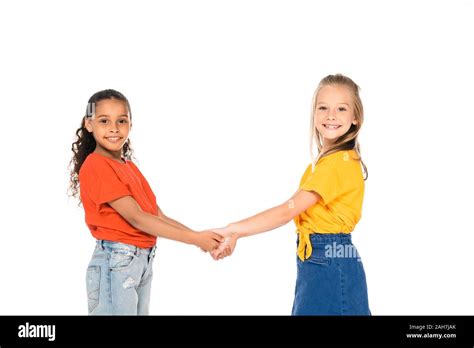 Two Cute Multicultural Friends Holding Hands And Smiling At Camera