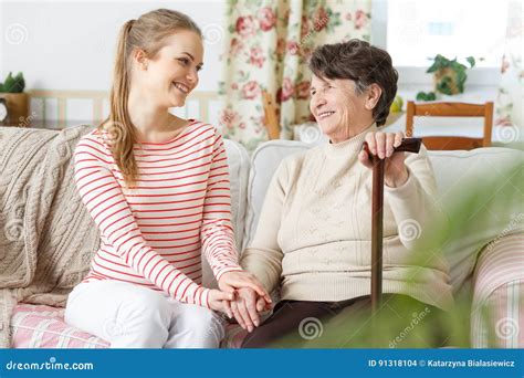 Granddaughter And Grandmother Sitting On A Sofa Stock Photo