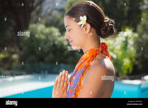 Brunette In Sarong Meditating By The Pool Outside At The Spa Stock