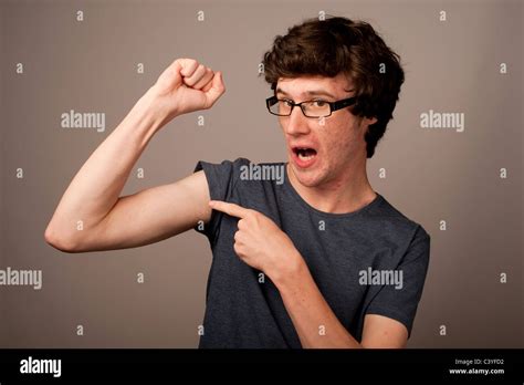 A Spotty Faced Weak Feeble Geek Nerd Young Man With Thin Arms Wearing