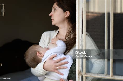 Foto De Bebê Mamando No Peito Da Mãe Na Janela E Mais Fotos De Stock De