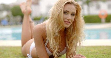 Seductive Looking Blond Woman Wearing White Bikini Lying On Stomach On Grass Next To Outdoor