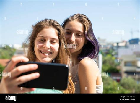 Two Teenage Girls Taking Selfie With A Mobile Phone Home Concept Stock