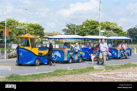 People Riding On The Noddy Train Along The Seafront Promenade In