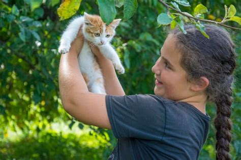 Una Ni A Sostiene Un Gato En Sus Brazos Foto Premium