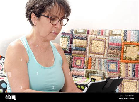 Brunette Mature Woman Using Tablet At Home Stock Photo Alamy