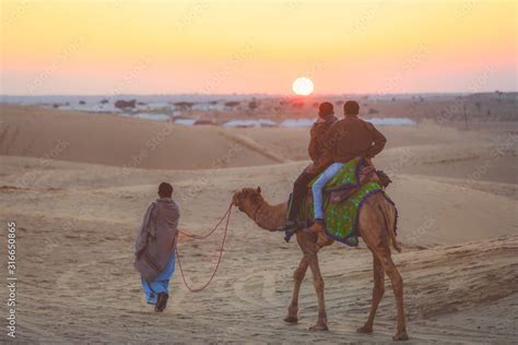 Tourists riding camel on Thar desert in Jaisalmer during the sunset ...