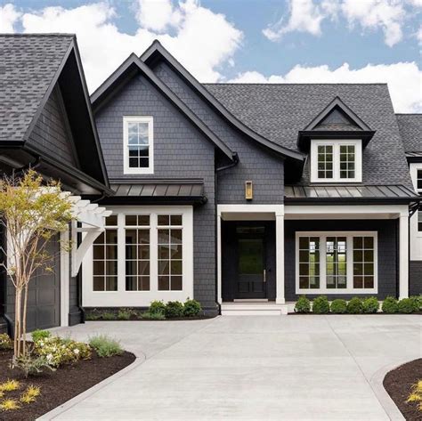 A Gray House With White Trim And Windows