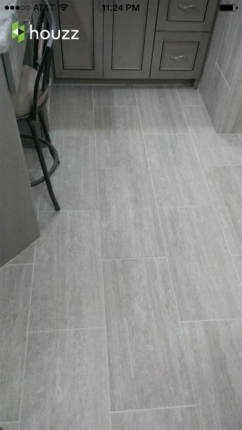 A Kitchen With Grey Tile Floors And Cabinets